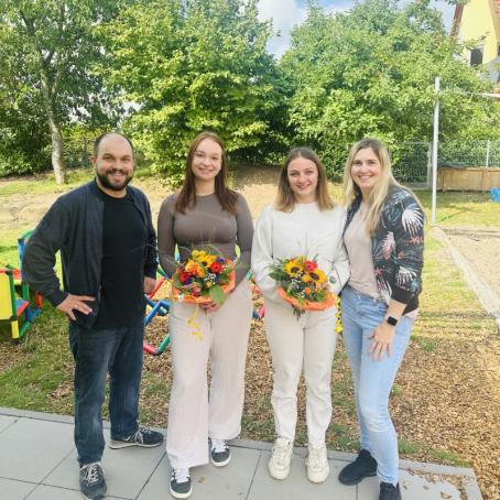 Lena Döngi (Mitte links) und Justine Brandt (Mitte rechts), stellv. Kita-Leitung Michelle Sagadin und Ortsbürgermeister Tobias Rohrwick freuen sich über den erfolgreichen Abschluss der Ausbildung.